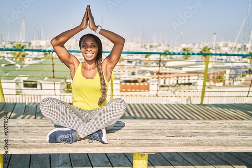 African american woman wearing sportswear doing yoga exercise at street © Krakenimages.com