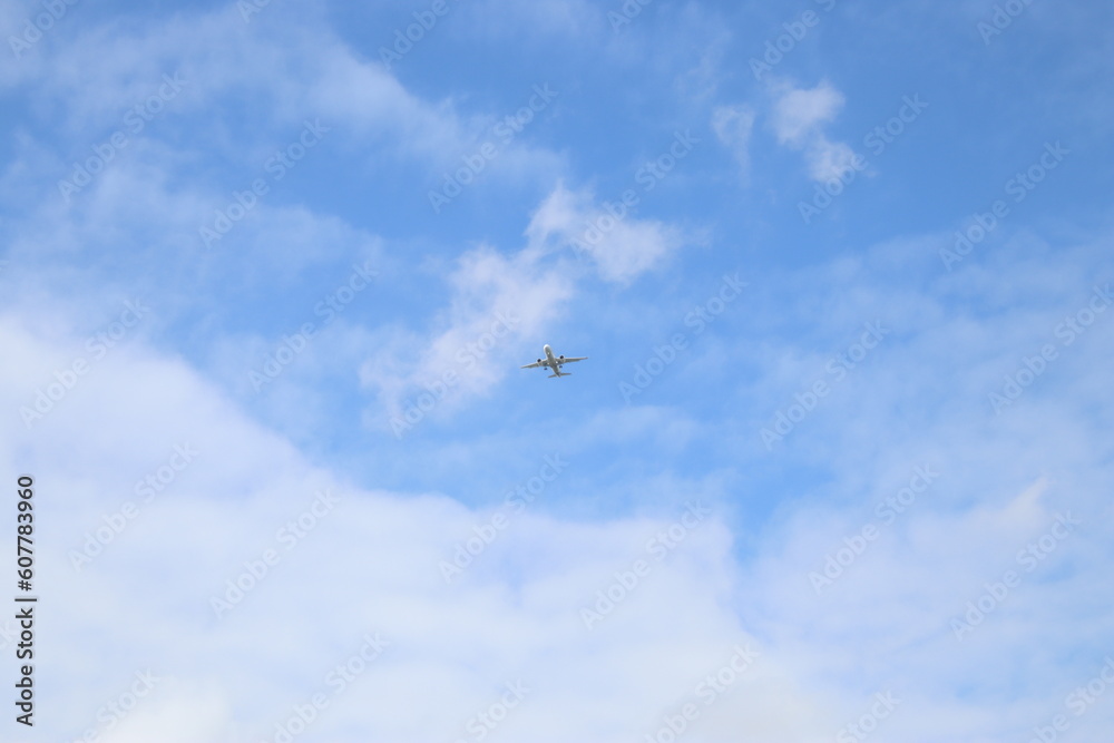 passenger airplane is flying in the blue sky with white clouds passenger airplane is flying in the blue sky with white clouds