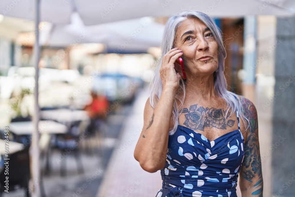 Fototapeta premium Middle age grey-haired woman smiling confident talking on the smartphone at street