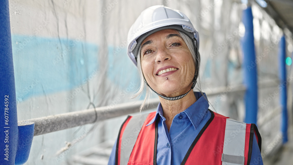 Middle age grey-haired woman builder smiling confident standing at street Middle age grey-haired woman builder smiling confident standing at street