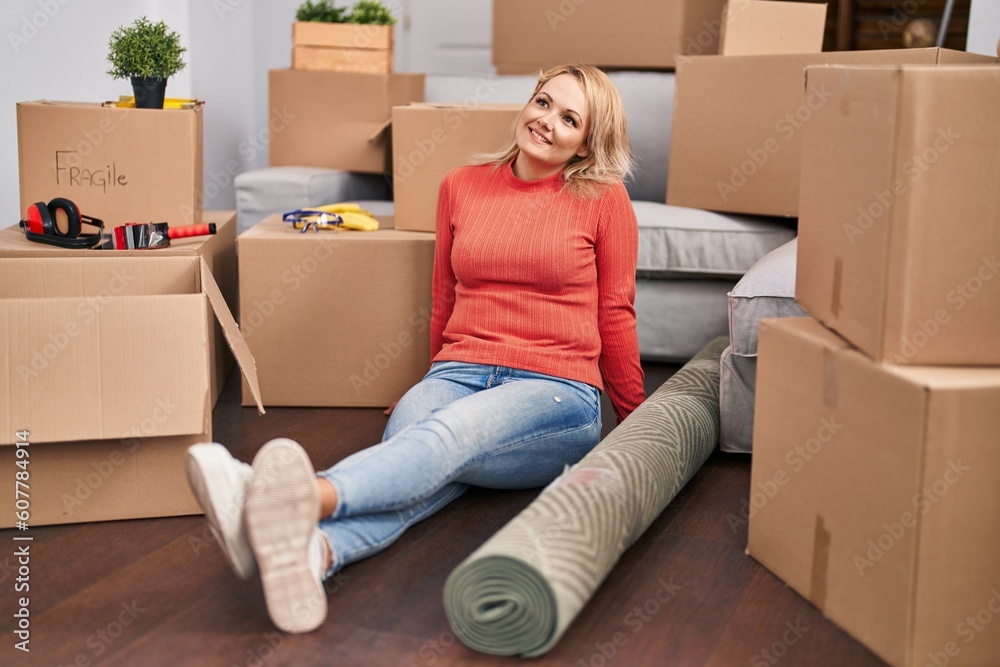 Young blonde woman smiling confident sitting on floor at new home Young blonde woman smiling confident sitting on floor at new home