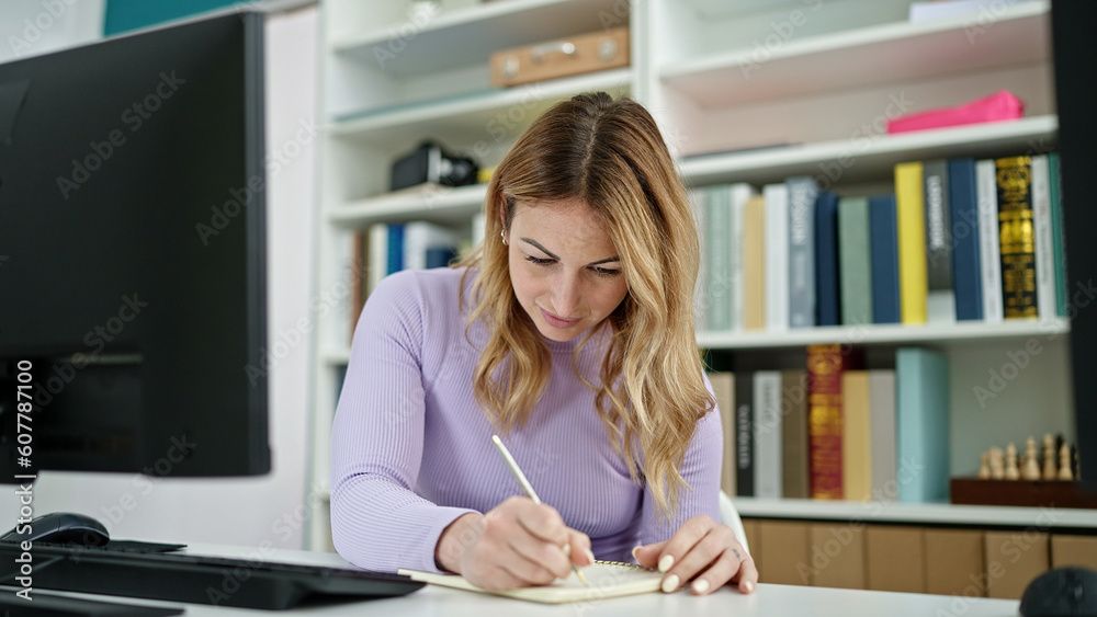 Young beautiful hispanic woman student using computer writing on notebook at library university Young beautiful hispanic woman student using computer writing on notebook at library university