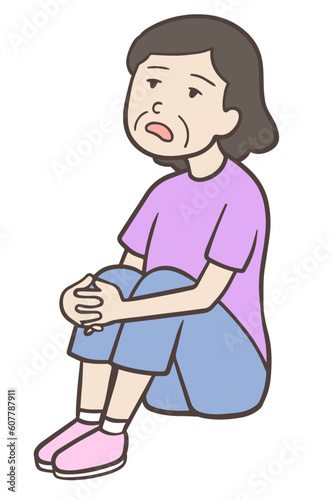 体育座りでぼんやりする中年女性