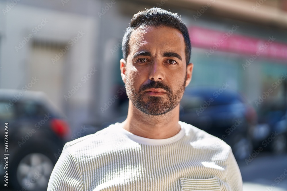 Young hispanic man with relaxed expression standing at street Young hispanic man with relaxed expression standing at street