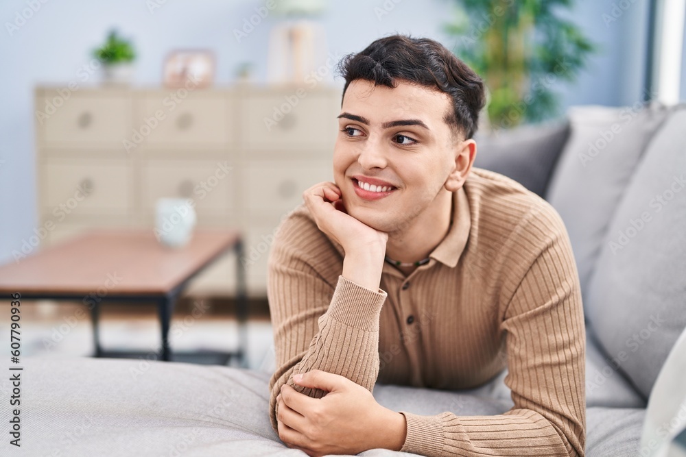 Young non binary man smiling confident lying on sofa at home Young non binary man smiling confident lying on sofa at home