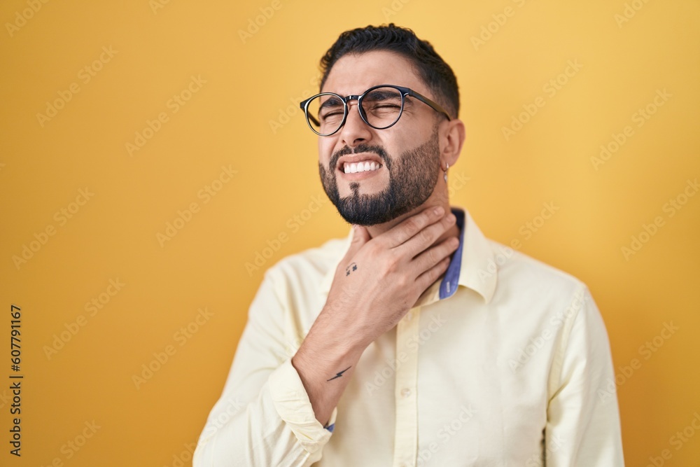 Hispanic young man wearing business clothes and glasses touching painful neck, sore throat for flu, clod and infection Hispanic young man wearing business clothes and glasses touching painful neck, sore throat for flu, clod and infection