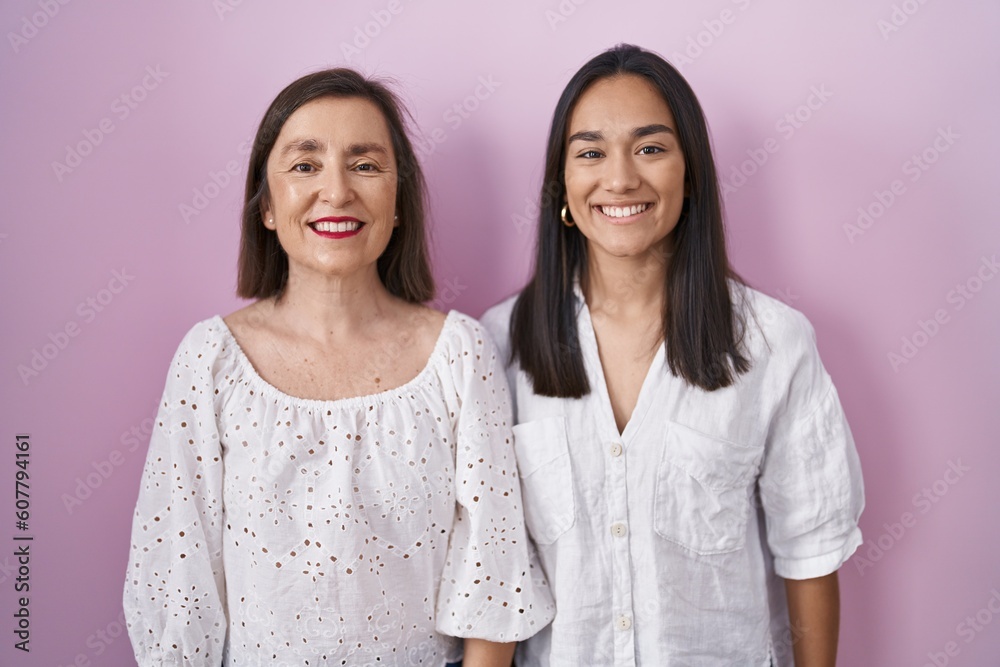 Hispanic mother and daughter together with a happy and cool smile on face. lucky person. Hispanic mother and daughter together with a happy and cool smile on face. lucky person.
