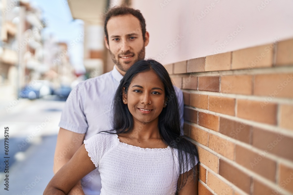 Fototapeta premium Man and woman interracial couple standing together at street