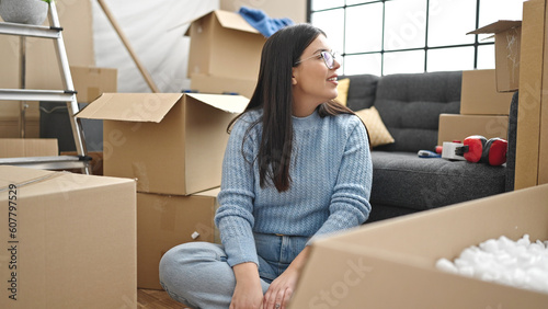 Young hispanic woman smiling looking around at new home