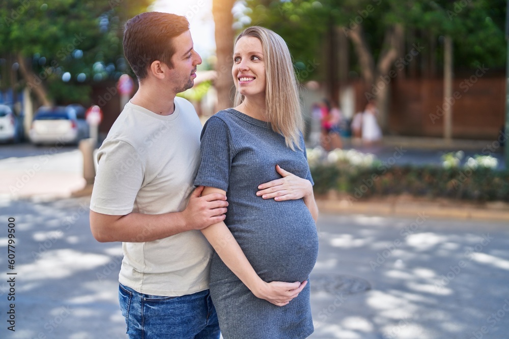 Man and woman couple hugging each other expecting baby at street