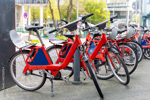 Canvas Print Closeup view many red city bikes parked in row at german Hamburg city street rental parking sharing station or sale