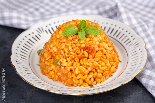 Traditional turkish bulgur pilaf with tomato sause in plate (Turkish name; meyhane pilavi)