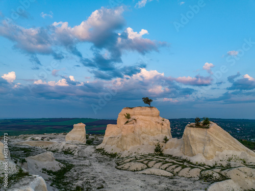  aerial view of Lonely Tree on top of rock with a Radiant Sunrise Behind in fetesti with beautiful sky on backround