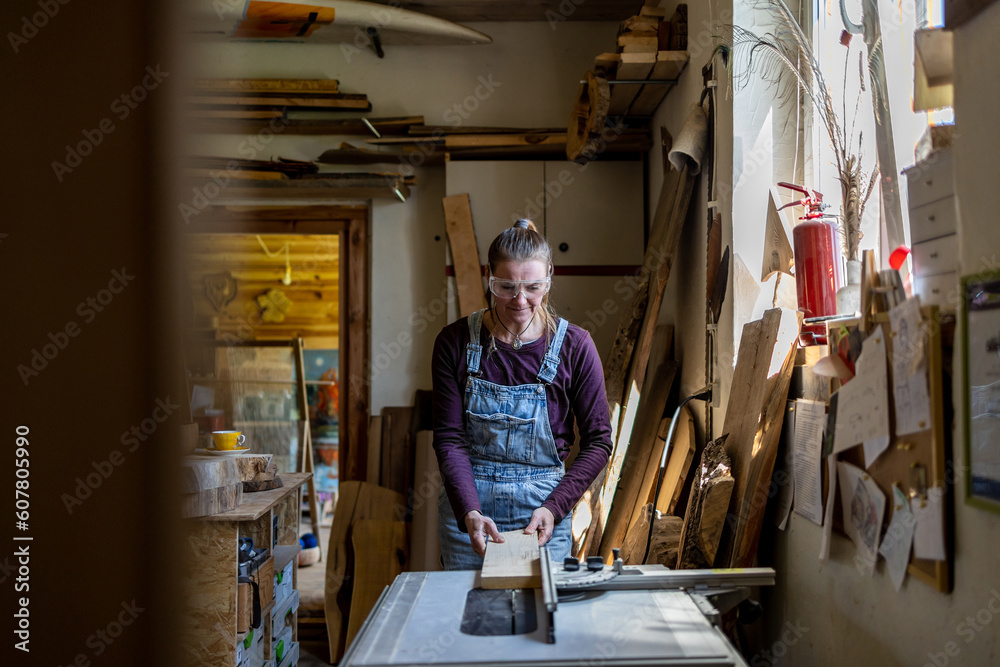 Craftswoman working with wood in carpentry workshop
Craftswoman working with wood in carpentry workshop