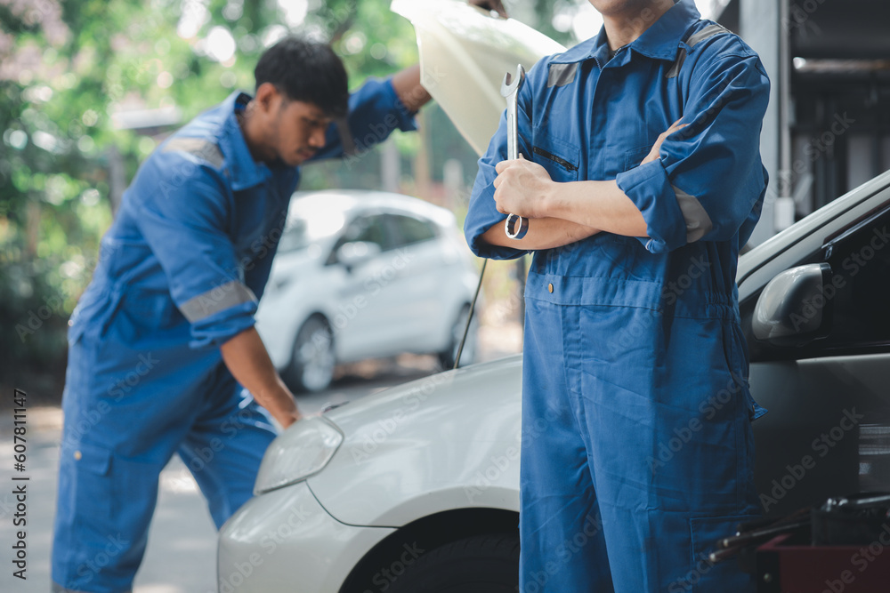 Car mechanic in uniform holding wrench at auto workshop, all kinds of auto specialists, expert auto repair and accredited auto repair centers. Car mechanic in uniform holding wrench at auto workshop, all kinds of auto specialists, expert auto repair and accredited auto repair centers.