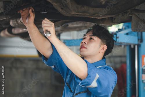 Professional car mechanic checking car undercarriage, all types of car specialists, expert auto repair and accredited car repair centers. © kamiphotos