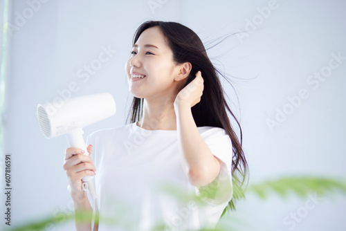 Plakat w ramie ドライヤーで髪の毛を乾かす健康的な日本人女性の夏のイメージ