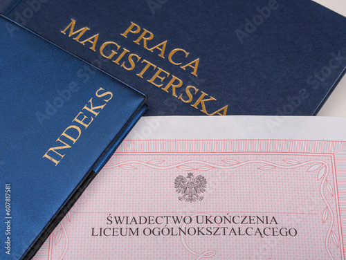 Świadectwo ukończenia liceum ogólnokształcącego leżące obok indeksów studenta i pracy magisterskiej  photo