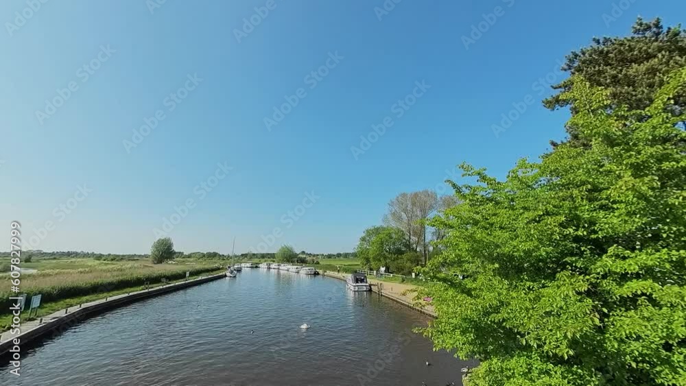 Panning shot of the River Bure in the heart of the Norfolk Broads National Park. Captured from Ludham Bridge on a bright and sunny morning Panning shot of the River Bure in the heart of the Norfolk Broads National Park. Captured from Ludham Bridge on a bright and sunny morning