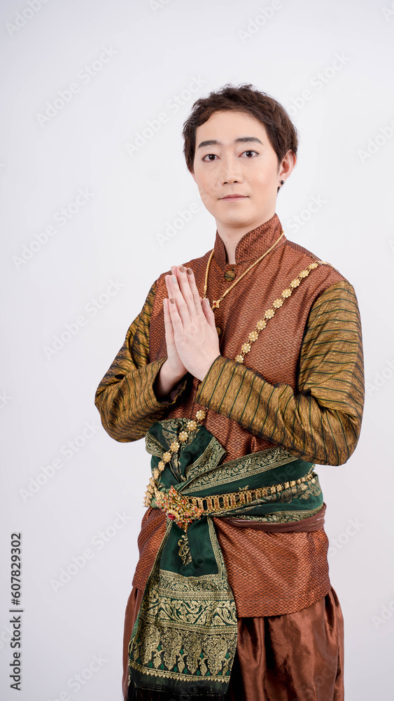 Asian man wearing typical, traditional Thai dress with identity Thai culture posing to pay respect with smiling isolated on white background