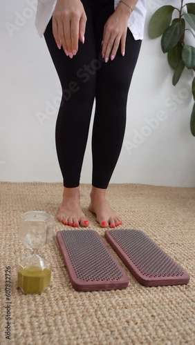 Sadhu board with sharp nail and hourglass. Standing on nails.