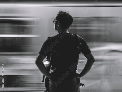 Person in front of blurred train in a metro station waiting for the metro photo