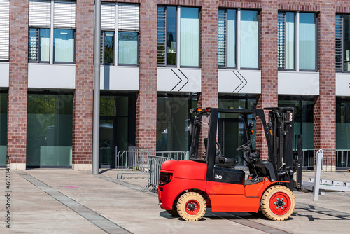 Forklift at a construction site against the backdrop of a large building. Side view.