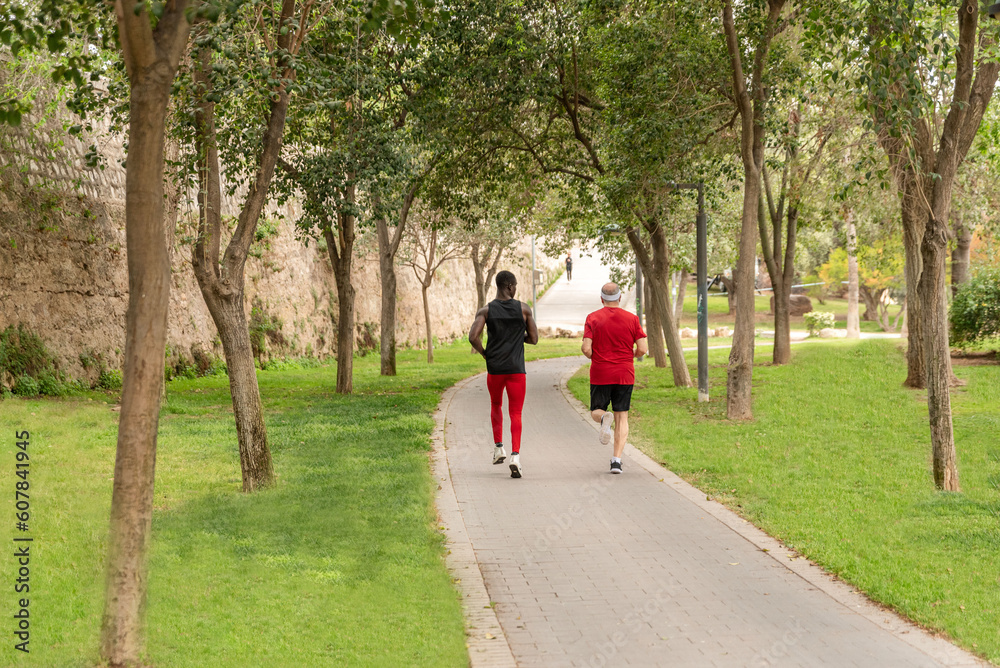 Diverse pair of sport men running in park Diverse pair of sport men running in park