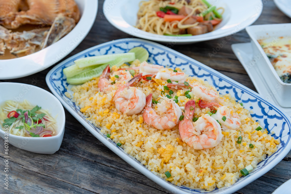 Fried rice with shrimp (Thai style) on wooden table that serve with main menu Fried rice with shrimp (Thai style) on wooden table that serve with main menu