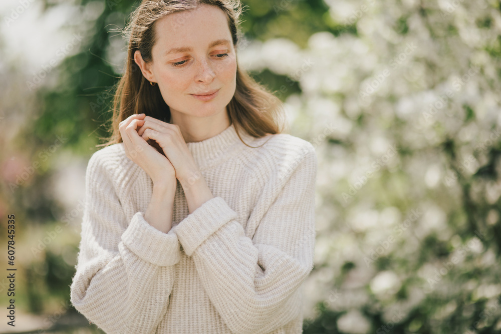 Young beautiful woman with freckles near blooming spring trees. Young beautiful woman with freckles near blooming spring trees.