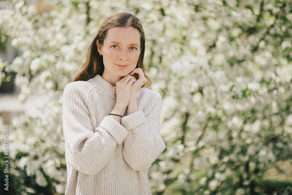 Young beautiful woman with freckles near blooming spring trees. Young beautiful woman with freckles near blooming spring trees.