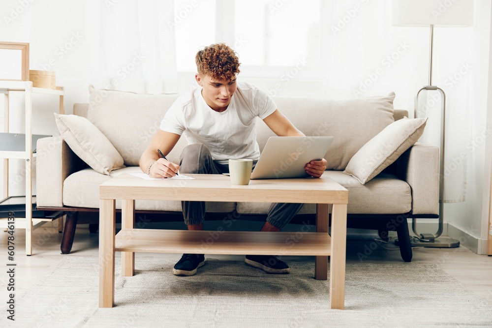 man adult t-shirt computer freelance chat browsing phone white indoor communication lifestyle sofa man adult t-shirt computer freelance chat browsing phone white indoor communication lifestyle sofa