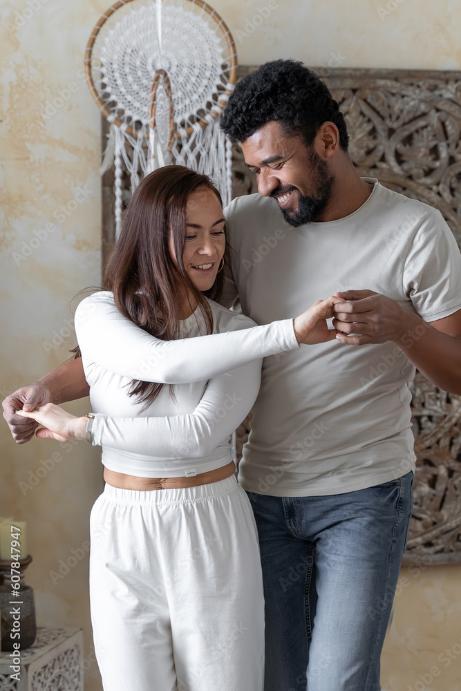 Multiethnic American couple embracing at home.