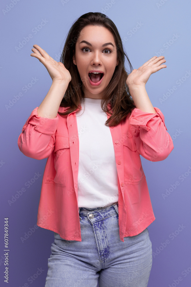 smiling brunette woman with hair below her shoulders in a shirt opened her eyes in anticipation of a surprise smiling brunette woman with hair below her shoulders in a shirt opened her eyes in anticipation of a surprise