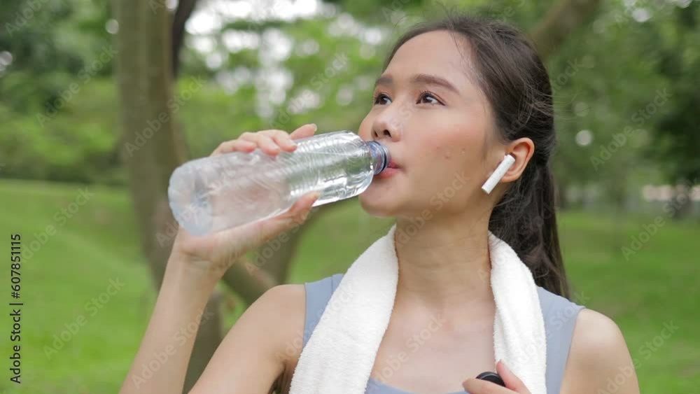 Asian beautiful woman Exercising outdoors in the park drinking water to quench your thirst after exercise. health care concept Asian beautiful woman Exercising outdoors in the park drinking water to quench your thirst after exercise. health care concept