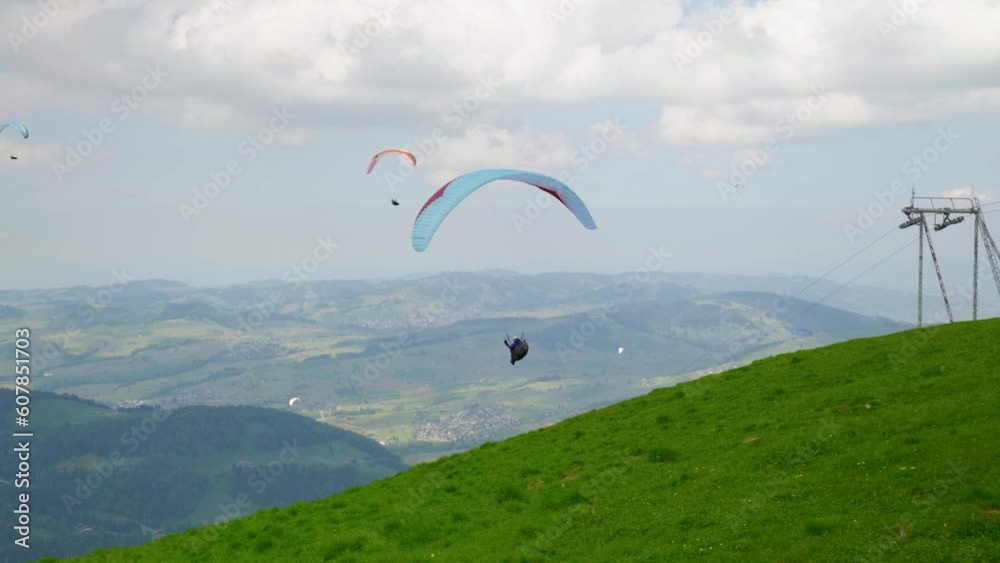Paragliders taking off the side of a mountain slope in Ebenalp, Appenzell region of Switzerland Paragliders taking off the side of a mountain slope in Ebenalp, Appenzell region of Switzerland