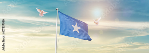 Waving Flag of Somalia in Blue Sky. The symbol of the state on wavy cotton fabric.