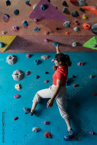 woman climbing on wall training in gym, active sporty female practicing rock climbing on artificial rock in extreme sport, bouldering, wall, climber is training, rock climbing in the city, strong
