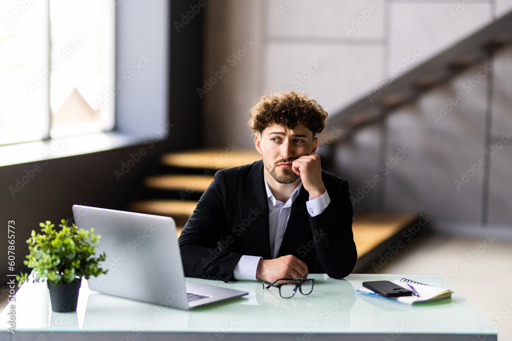 Fototapeta premium Young businessman typing on laptop at workplace