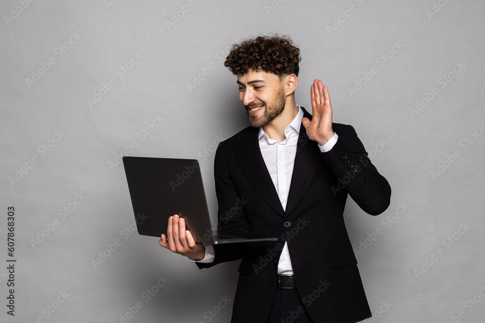 Man business stares at laptop video call business talks on gray background