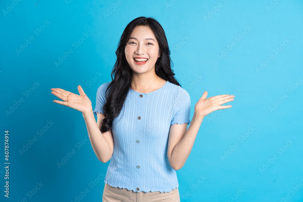Portrait of a happy smiling asian girl posing on a blue background Portrait of a happy smiling asian girl posing on a blue background