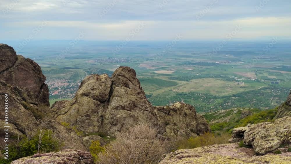 Panoramic view of the valley on top of the rocky ridge among the stones overlooking the beautiful valley. Outdoor and mountain hike background. Natural landscape in Bulgaria, Sliven Panoramic view of the valley on top of the rocky ridge among the stones overlooking the beautiful valley. Outdoor and mountain hike background. Natural landscape in Bulgaria, Sliven