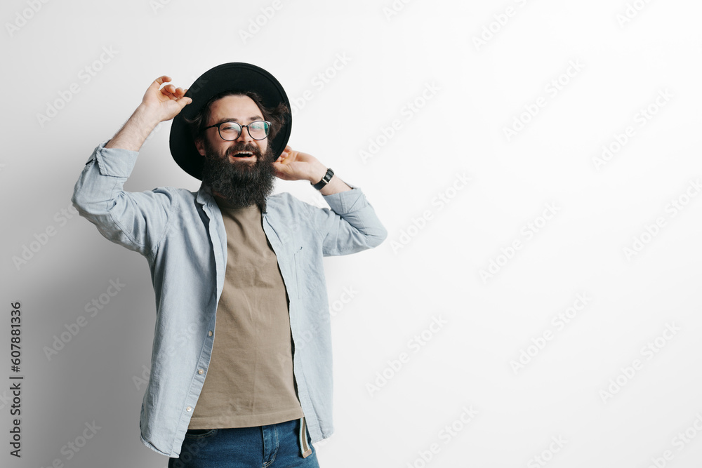 Handsome stylish man with beard on white background. Smiling man wearing black hat and glasses Handsome stylish man with beard on white background. Smiling man wearing black hat and glasses