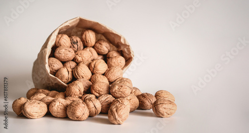 Walnut in a paper bag on a white background. Natural ingredient. Close-up, shopping grocery concept, nuts delivery. Zero Waste Food Shopping. Copy space