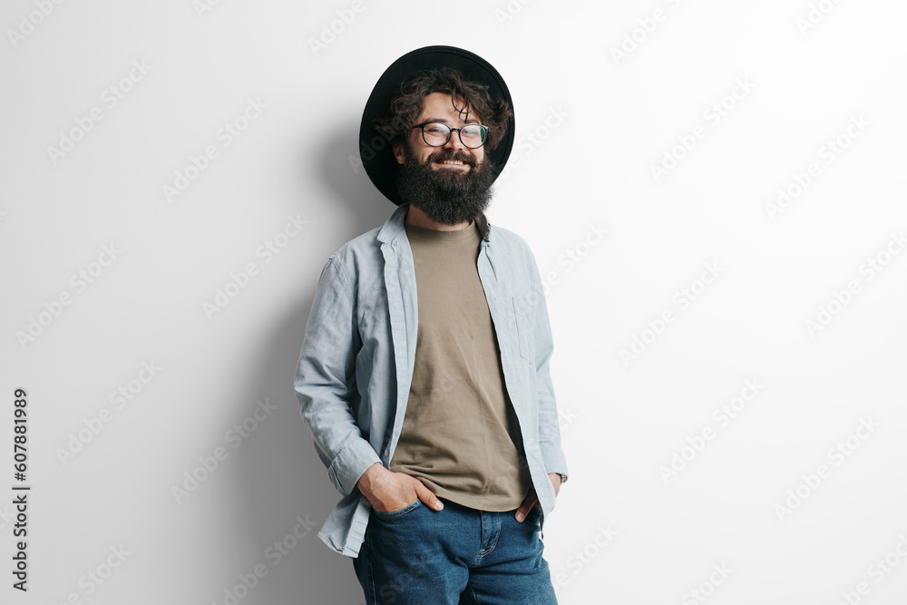 Handsome stylish man with beard on white background. Smiling man wearing black hat and glasses Handsome stylish man with beard on white background. Smiling man wearing black hat and glasses