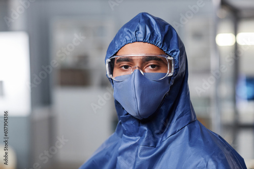 Closeup portrait of scientist wearing full protective gear in laboratory and looking at camera, copy space