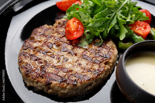 mouthwatering grilled pork steak topped with savory sauce, peppery arugula and ripe tomatoes