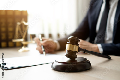 The lawyers sitting in their office is meticulously examining the judicial documents to gather crucial information and build a strong legal strategy for their client's case.