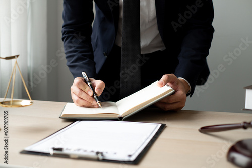 The lawyers is meticulously examining the judicial documents to gather crucial information and build a strong legal strategy for their client's case.
