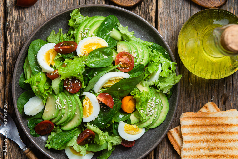 Salad with spinach, avocado, tomatoes in a plate. Vegetarian salad